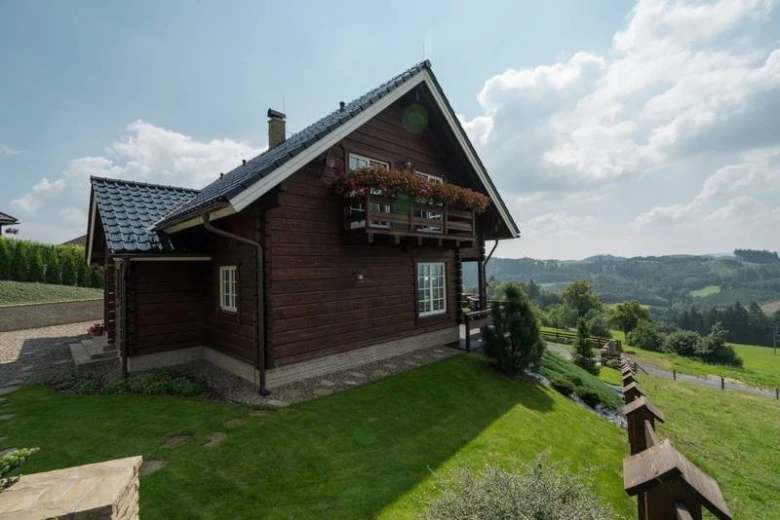 Dřevěný dům s balkonem na kopci
