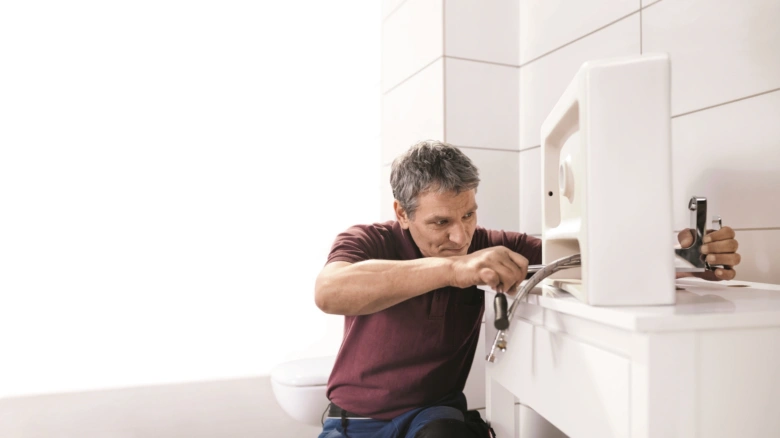 Montáž umyvadla: instaluje sanitární technik hadici pod umyvadlo.