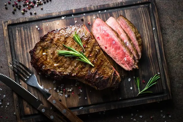 Hovězí steak na dřevěné desce s rozmarýnem a kořením