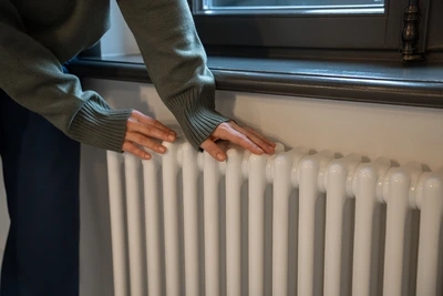 Dotýkání se bílého radiátoru v interiéru