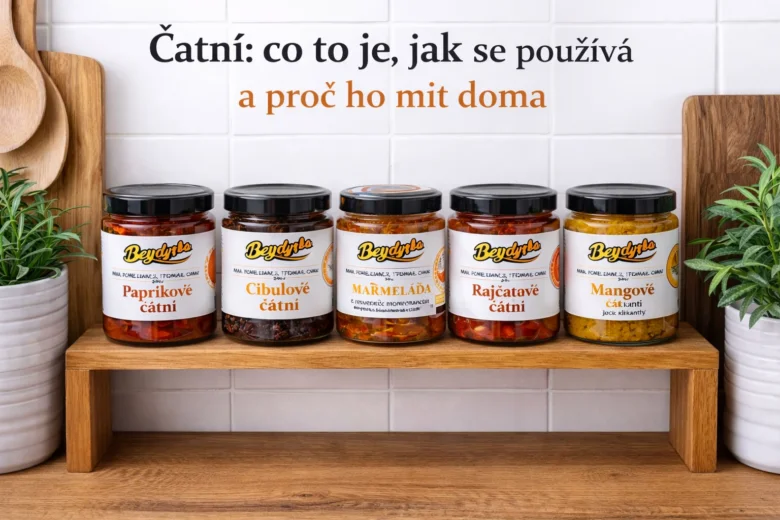 Pět sklenic čatní různých druhů na dřevěném podstavci.
