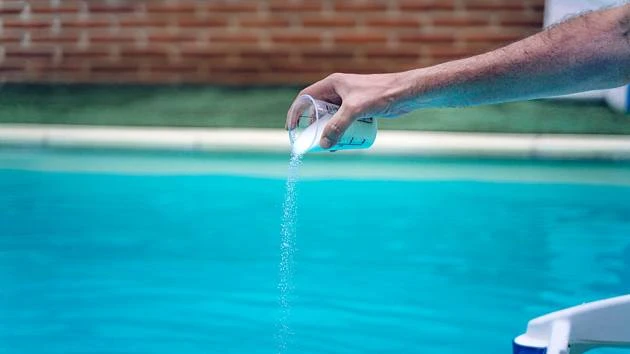 Rozpouštění chemie do bazénu měřicí šálkem