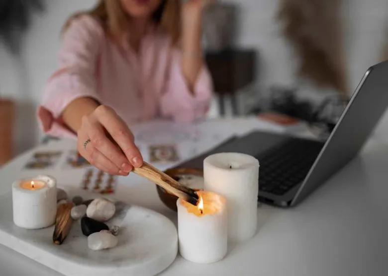 Žena čistí energii v domě pomocí pálené šalvěje.