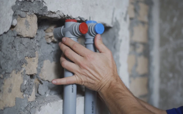 Ruční instalace potrubí pro systém topení v budově.