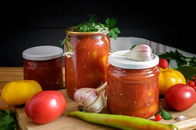 Zavařené lečo v sklenicích s čerstvými zeleninovými ingrediencemi.