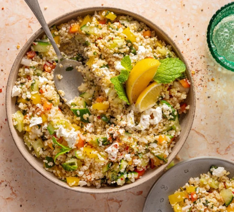 Bulgur salát s fetou, mátou a citronem v misce.