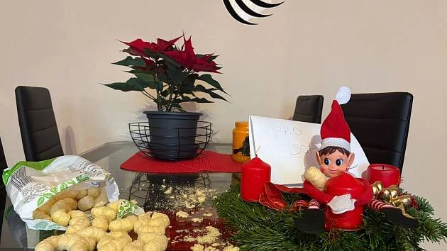 Vánoční skřítek s kořistí na vánočním stole.