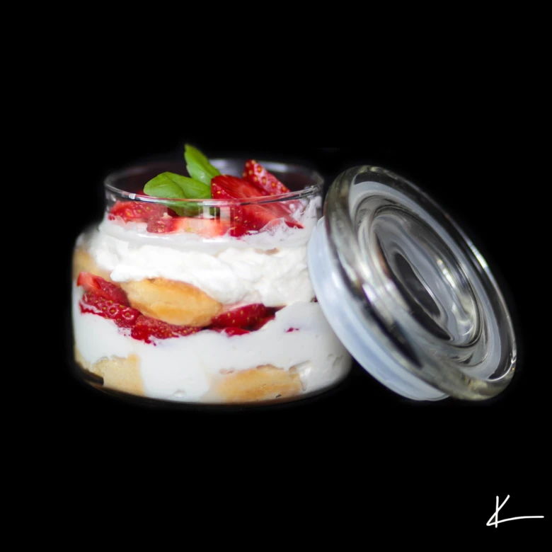 Jahodové tiramisu v skleničce s vrstvami smetany.