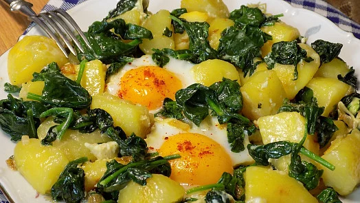 Hot dish with potatoes, eggs and fresh processed spinach