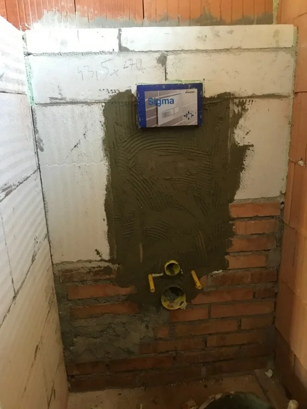Instalace Geberitu: omítka na zdi nad červenými cihlami