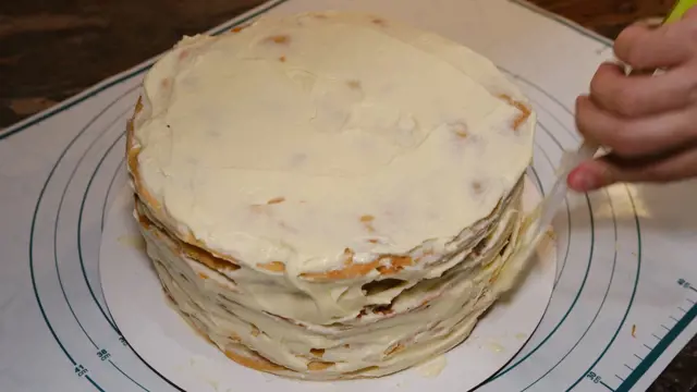 Náplňování dortu napoleon bílou smetanou.