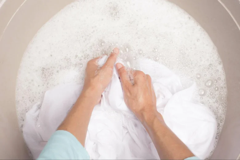 Ruční praní bílého oblečení v mýdlové vodě