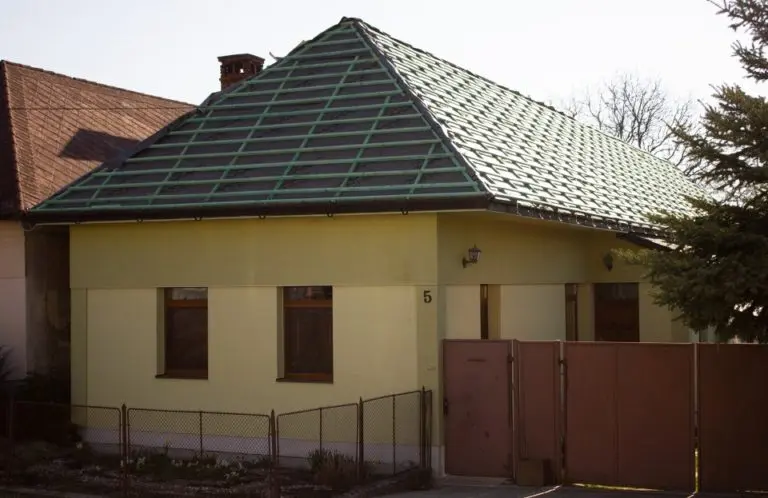 Dům s viditelnými vazními krovami na střeše.