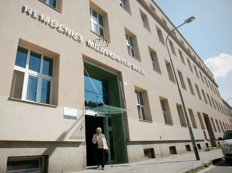 Vstup do nemocnice milosrdných bratrí s ženou venku.