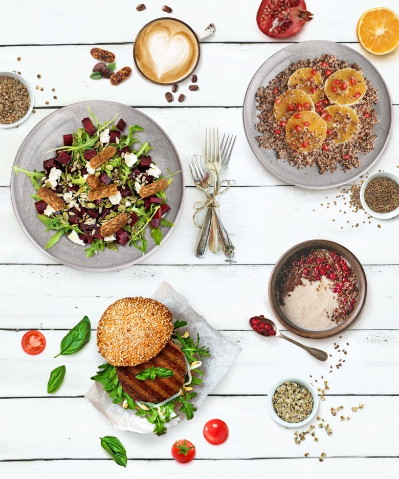 Zdravé jídlo: salát, quinoa a burgr na bílém stolu.