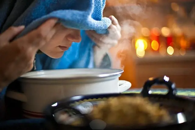 Člověk dýchá páru z horké vody pro uvolnění nosu.