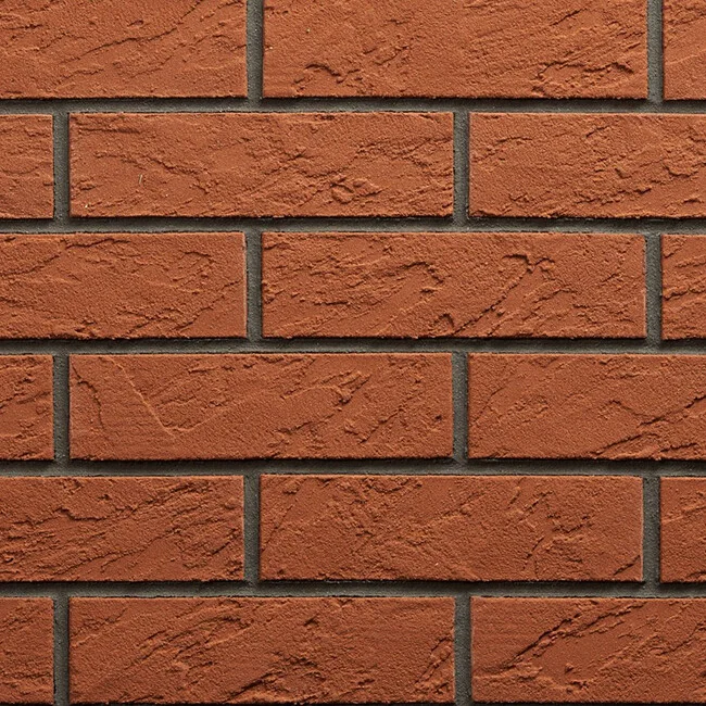 Detail červené cihlové zdi s viditelnými švy.