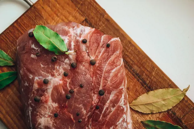 Hovězí steak s černým pepřem a listy hrušky na dřevěné desce