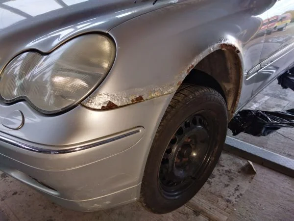 Povrchová korozie na nárazníku vozu před opravou autoklempířem.