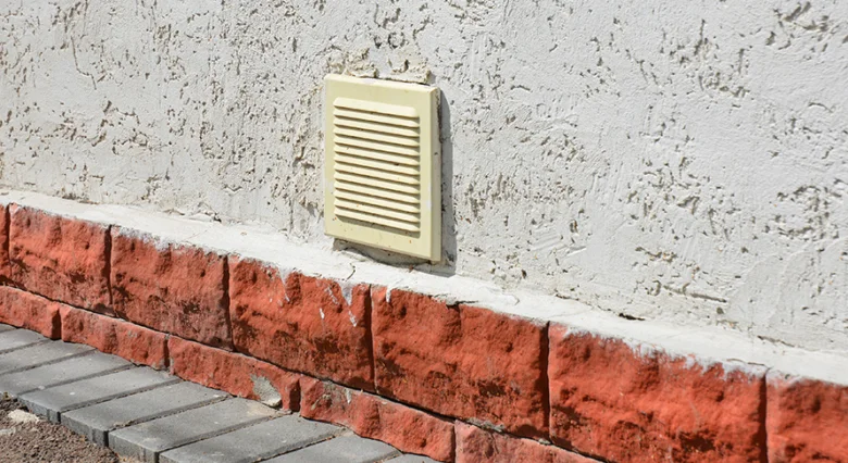 Žlutý větrací otvor na zdi garáže pro odvětrání.