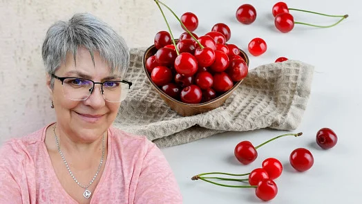 Ženy s miskou čerstvých třešní na pozadí.