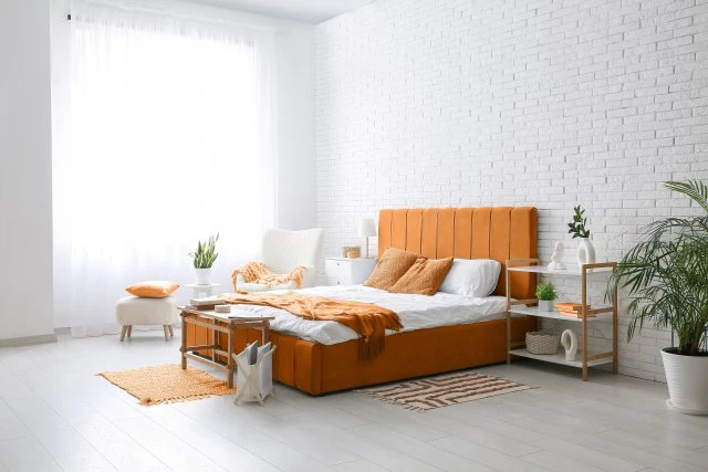 Jasná ložnice s oranžovou postelí pro útulný domov.