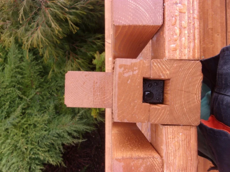 Detail dřevěného spojení na balkonu s kapkami vody