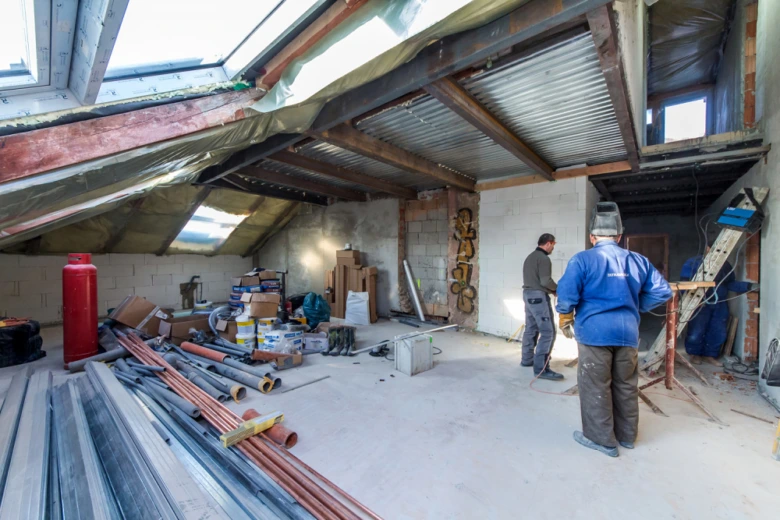 Stavba podkroví s materiály a dělníky před dokončením