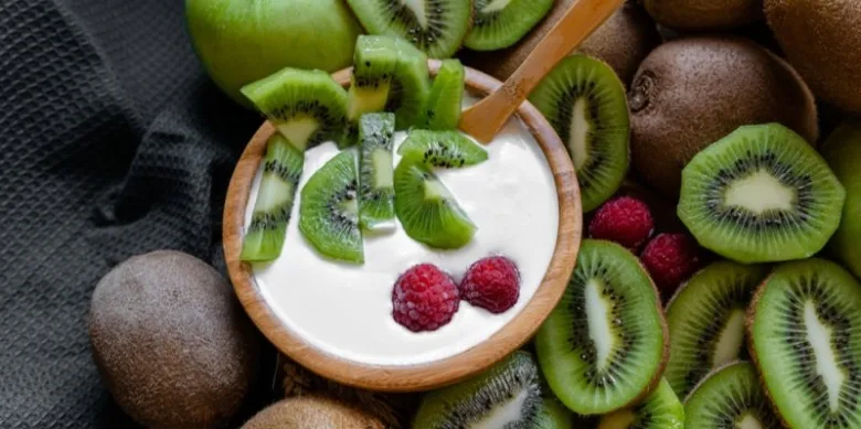 Jogurt s kivi a malinami na tmavém pozadí.