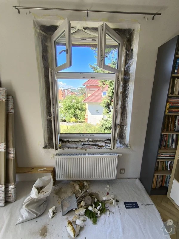 Okno v procesu renovace s odstraňovanou starou špaletou.