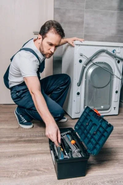 Technician fixing washing machine