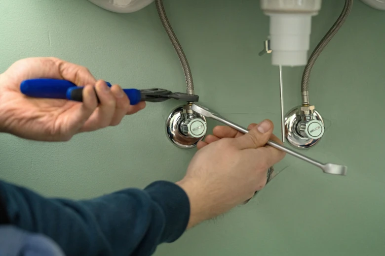 Ruční úprava vodovodních ventilů při montáži umyvadla.