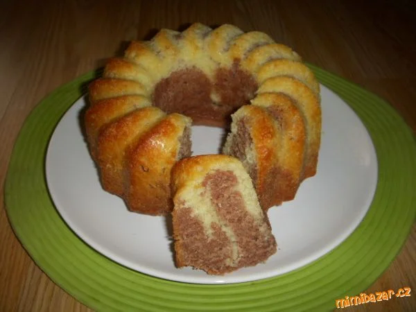Hotová mramorová bábovka na talíři s kouskem.