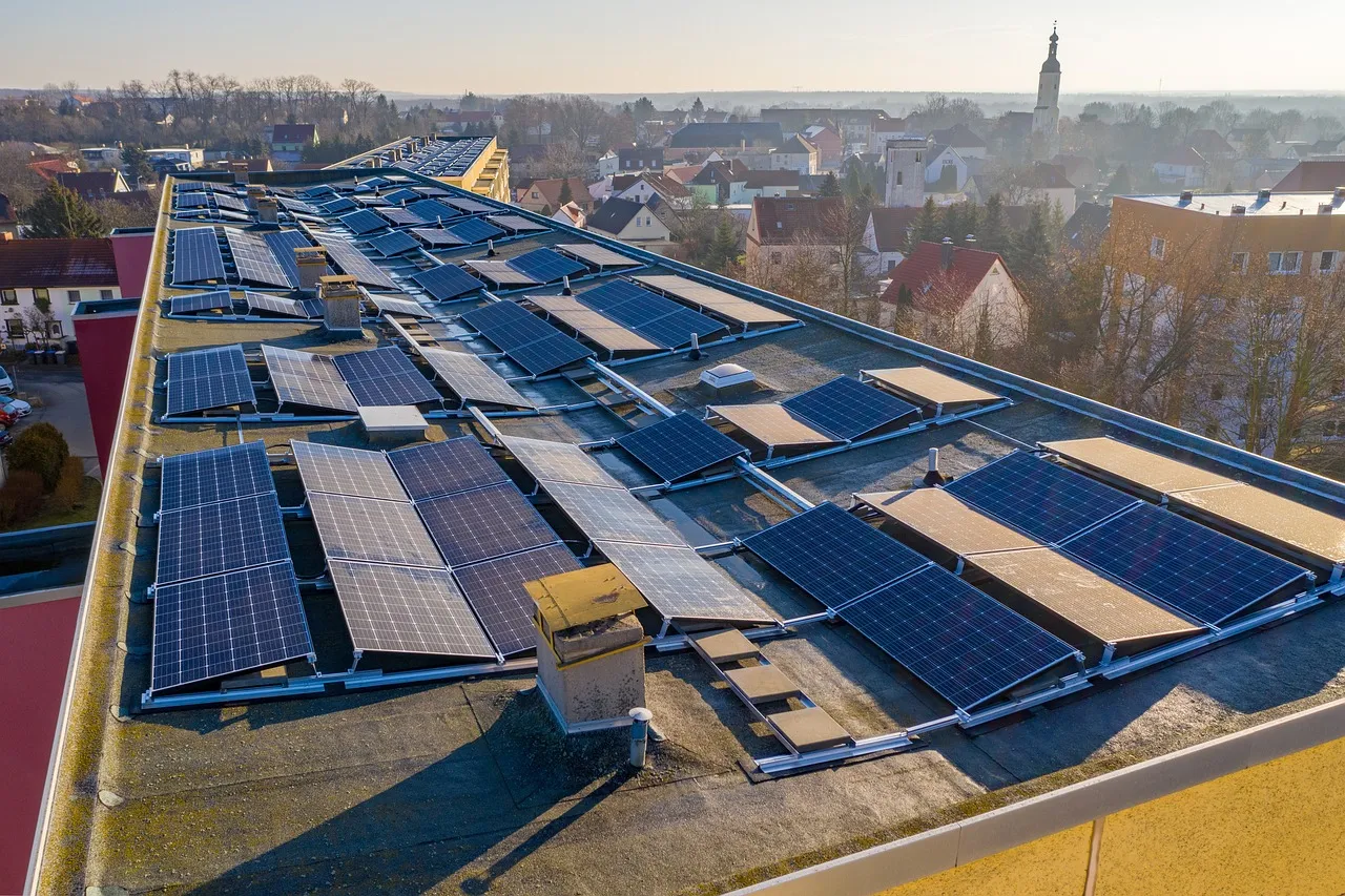 Fotovoltaické panely na střeše budovy v malém městě.
