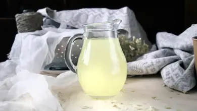 Sklenička s citronovým nápojem na dřevěném povrchu.