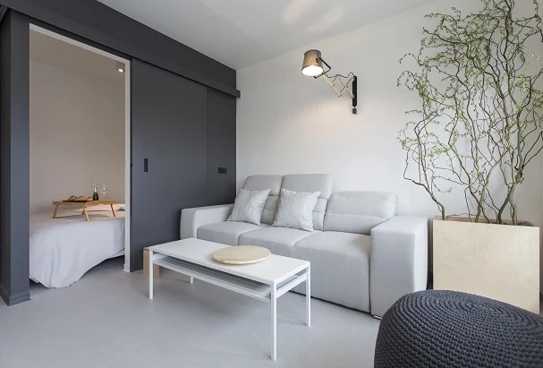 Moderní interiér s tmavě šedými posuvnými dveřmi do ložnice.