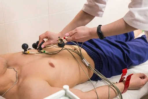 Připevňování elektrod pro tlakový holter na hrudi pacienta.