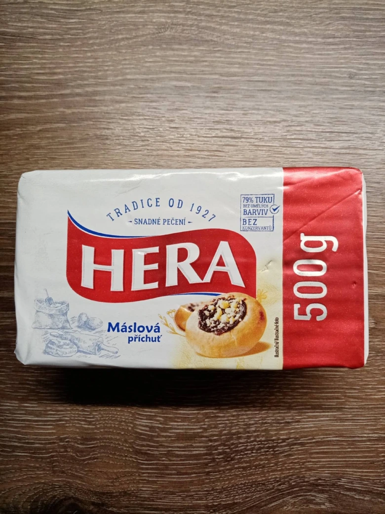 Balíček másla značky HERA s hmotností 500 g.