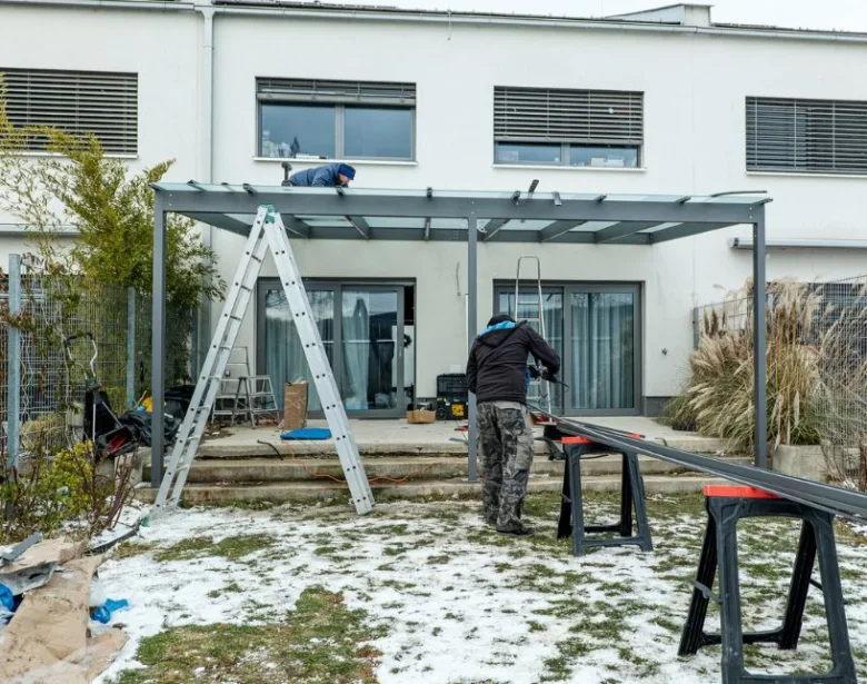 Práce na montáži kovové pergoly v zahradě s pracujícími.