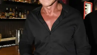 Martin Maxa stojí v baru s poličkami plnými láhví za ním.