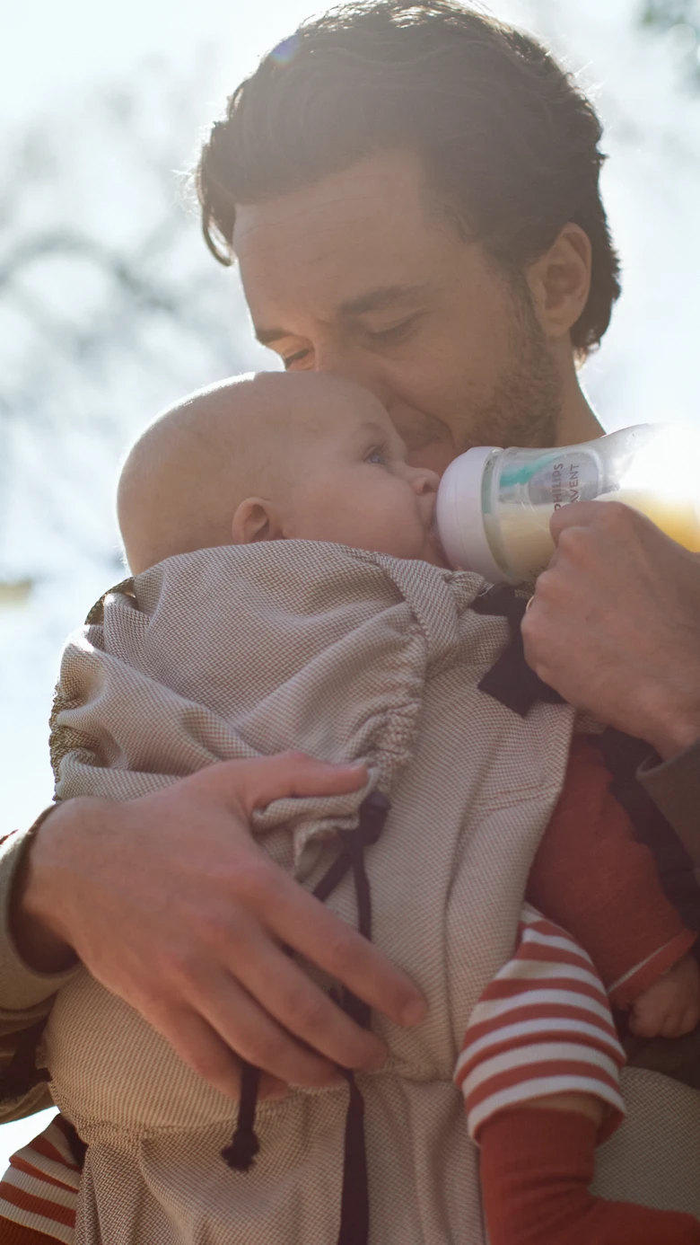 Father feeding baby outdoors
